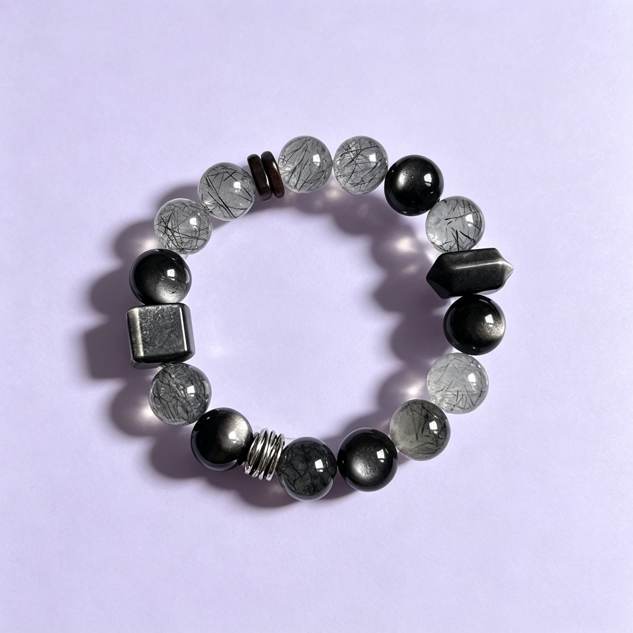 Retouched photograph of bracelet 002: smoky tones · silver-tone accents